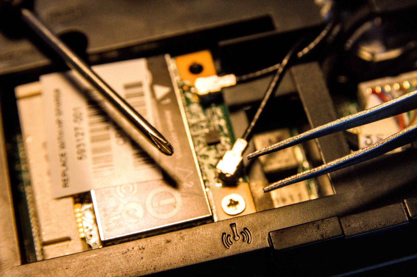 Close-up laptop repair with precision tools